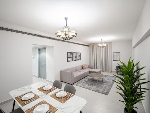 a living room with a table and a couch at Soft touch & Spacious 2 Bed next to Metro in Dubai