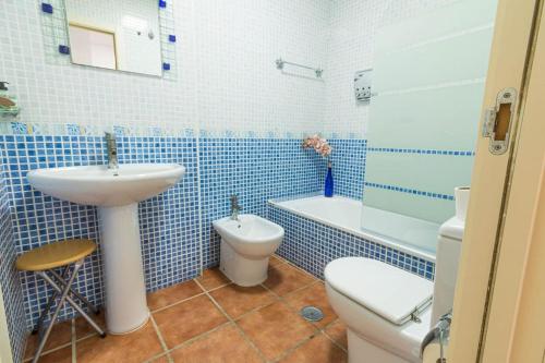 een blauw betegelde badkamer met een wastafel en een toilet bij Isleta 5 in La Isleta del Moro
