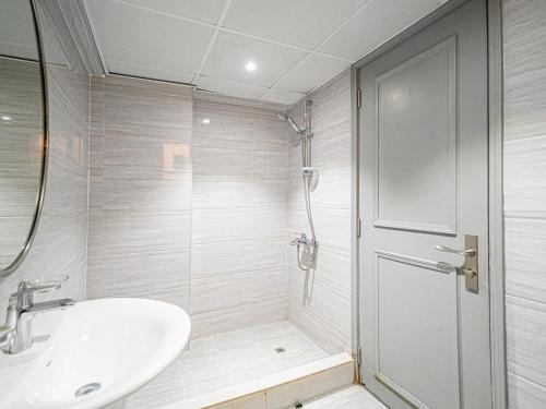 a white bathroom with a sink and a shower at Soft touch & Spacious 2 Bed next to Metro in Dubai