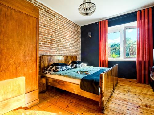 托伦Apartament Kraszewskiego 44 z balkonem, cegła- koło parku, ogród dla gości, rowery free的一间带床和砖墙的卧室