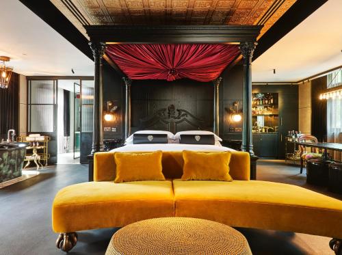 a bedroom with a large bed with a red curtain at Chateau Denmark London in London