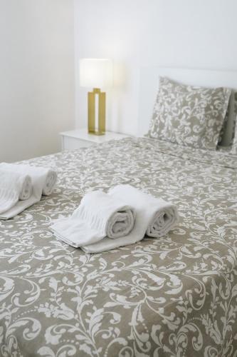 a bed with towels on top of it at Host Wise - Sweet & Sunny Flat - Ace Location in Quarteira