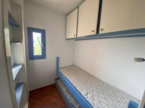 une petite pièce avec un lit et une fenêtre dans l'établissement Studio cabine 4 pers avec piscine, parking et animaux admis - Port Barcarès - FR-1-81-447, au Barcarès