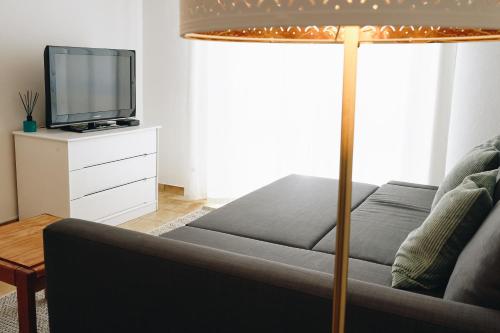 a living room with a couch and a tv at Host Wise - Sweet & Sunny Flat - Ace Location in Quarteira