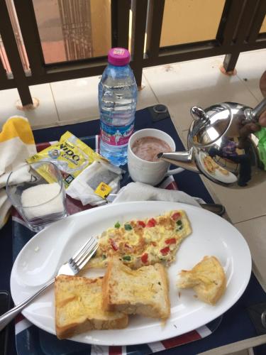 a plate with two slices of pizza on a table at Marrets International Hotel - "Express" in Cape Coast