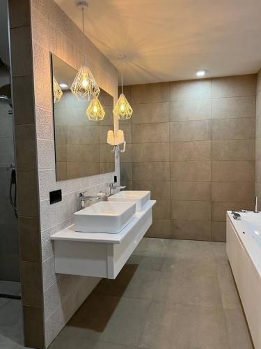 a bathroom with two sinks and a mirror and a tub at Hotel Zefir in Drohobytsch