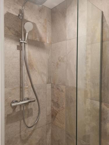 une douche dans une salle de bain avec une porte vitrée dans l'établissement Domaine de Maeva, à Romans-sur-Isère