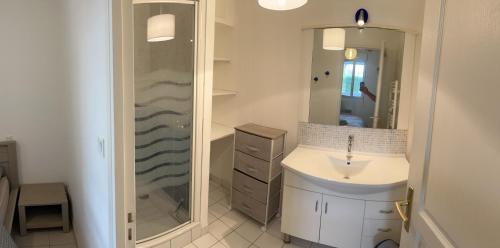 La salle de bains est pourvue d'une douche et d'un lavabo blanc. dans l'établissement KER LIZEA - Damgan - 4 personnes - 300 m de la grande plage, à Damgan