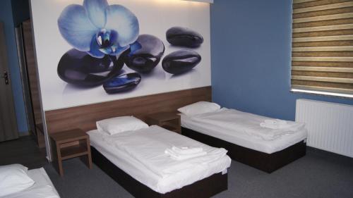 a room with two beds and hats on a wall at Jordaszka in Wodzisław Śląski
