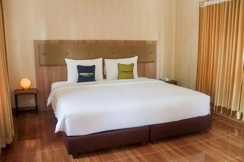 a bedroom with a large white bed with two pillows at Urbanview Hotel Belitung Lodge Resto & Club House by RedDoorz in Simpangempat