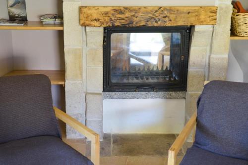 two chairs sitting in front of a fireplace at Les Caselles, Gîte et Chambre d'hôtes in Saint-Beauzély