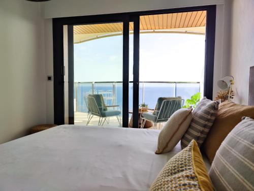 une chambre avec un lit avec vue sur l'océan dans l'établissement SUNSET WAVES fresh apartments, à Benidorm