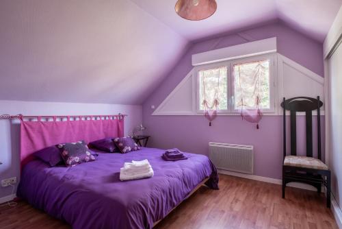 Dormitorio púrpura con cama púrpura y ventana en Le Chant des Oiseaux en Trédion