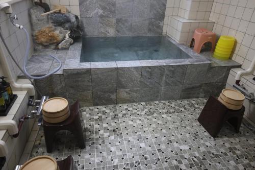 a bathroom with a tub with two toilets and a sink at Yuzawa Ski House in Yuzawa