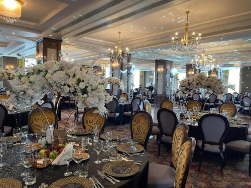 um salão de banquetes com mesas e cadeiras com flores brancas em Hotel Select em Sibiu