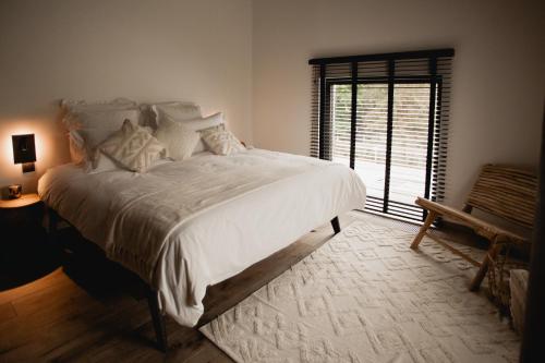 sypialnia z dużym białym łóżkiem i oknem w obiekcie Comme chez Lore - villa 2pers - piscine chauffée w mieście Namur