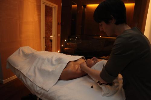 a man helping a man laying on a bed at Devero Hotel & Spa, BW Signature Collection in Cavenago di Brianza