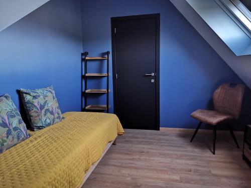 1 dormitorio con cama, puerta negra y silla en Le Rougegorge, 