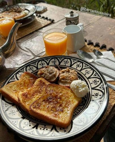 a plate of food with toast and butter and orange juice at Libert'Art in Essaouira