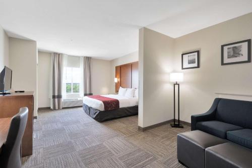 a hotel room with a bed and a couch at Comfort Suites University in Abilene