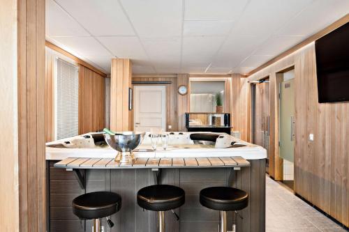 a kitchen with a counter with stools in it at Sure Hotel by Best Western Vilsta Sporthotell in Eskilstuna
