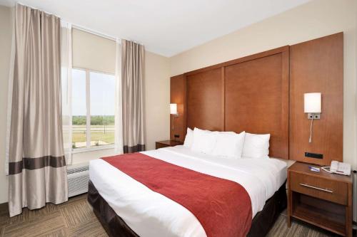 a hotel room with a large bed and a window at Comfort Suites University in Abilene