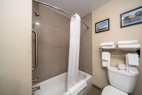a bathroom with a shower and a toilet with towels at Comfort Suites University in Abilene