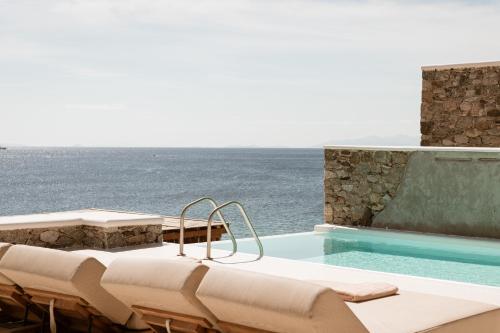 a swimming pool with a view of the ocean at Casa Del Mar - Small Luxury Hotels of the World in Agios Ioannis Mykonos