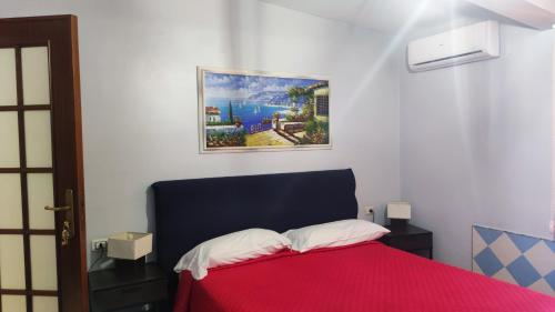una camera da letto con un letto rosso e un dipinto sul muro di La Villa Franca Pompeii a Pompei