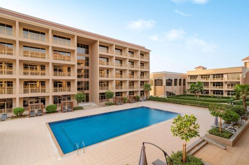 a swimming pool in front of a building at Radisson Hotel Riyadh Airport in Riyadh