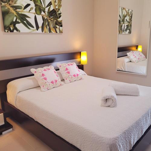 a bedroom with a bed with pink and white pillows at Mi casa playera in El Rompido