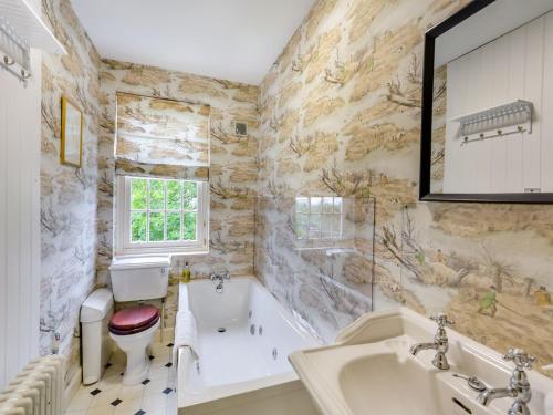 a bathroom with a tub and a toilet and a sink at The Wing At Brook Hall in Newton Kyme