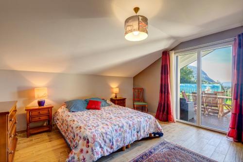 una camera da letto con un letto e una grande finestra di La Vougerotte - Terrasse Vue Montagnes a Vougy