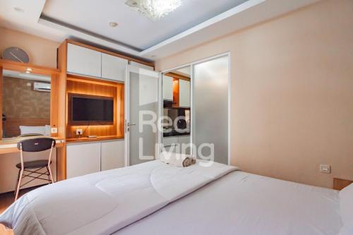 a bedroom with a white bed and a desk at RedLiving Apartemen Gateway Pasteur - TN Hospitality 3 Tower Jade B in Bandung