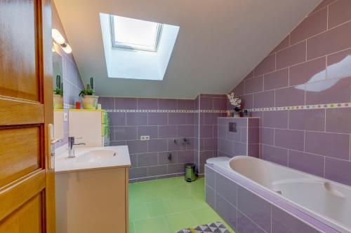 a bathroom with purple tiles and a tub and a sink at La Vougerotte - Terrasse Vue Montagnes 