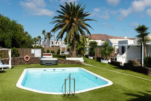 a swimming pool in the middle of a yard at Villas New Lanzasuites in Playa Blanca