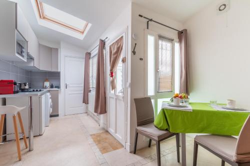 une cuisine et une salle à manger avec une table et des chaises vertes dans l'établissement Nid d'amour - à 900m de la Tour Eiffel, à Paris