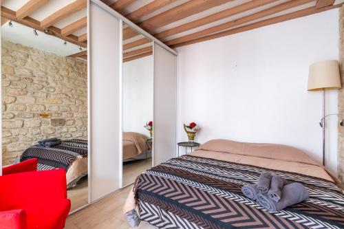 une chambre avec un lit et une chaise rouge dans l'établissement Nid d'amour - à 900m de la Tour Eiffel, à Paris