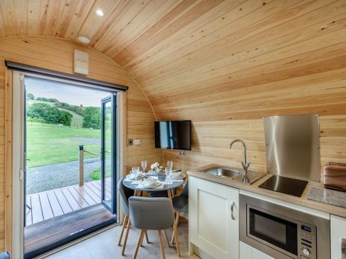 a kitchen in a tiny house with a dining table at Elm-uk36259 in Llanfair Caereinion