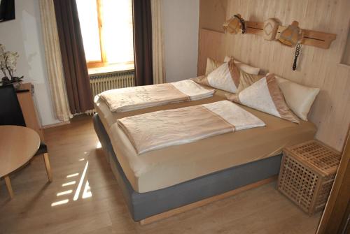 a bedroom with a bed and a table and a window at Gasthof Schwarzer Adler in Nabburg