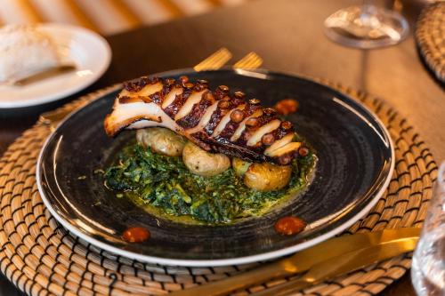 a black plate of food on a table at Eurostars Santa Luzia in Guimarães