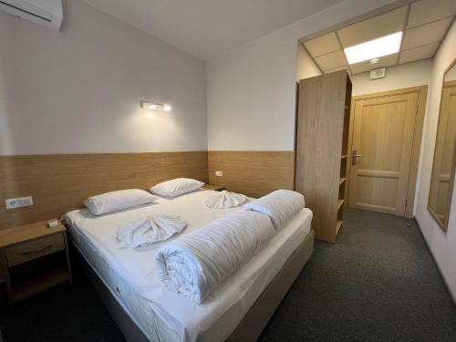 a bedroom with a large bed with white sheets at Iris Hotels Resort in Vorzelʼ