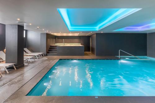 a swimming pool in a hotel with a blue ceiling at Barceló Aracena & Spa in Aracena