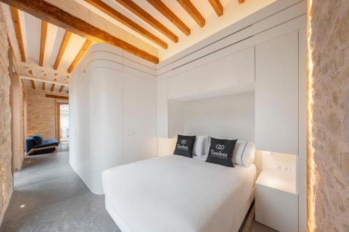 Tandem Pórtico Alicante Suites في أليكانتي: غرفة نوم بسرير ابيض وسقف خشبي