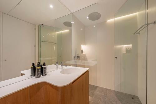 ein Bad mit einem Waschbecken und einer Dusche in der Unterkunft Tandem Pórtico Alicante Suites in Alicante