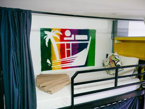 um beliche num barco com uma pintura na parede em K-Bunk Hostel em Praia de Aonang