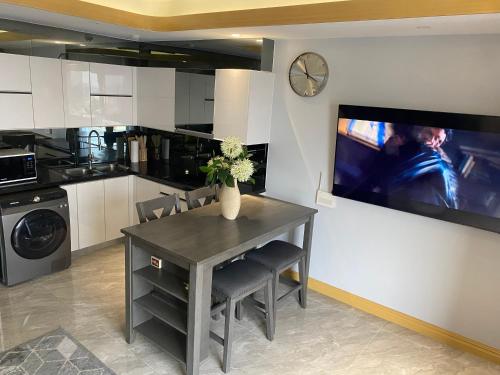 a kitchen with a table and a tv on a wall at Walking Street Condo Beautiful 1 king bedroom in Angeles