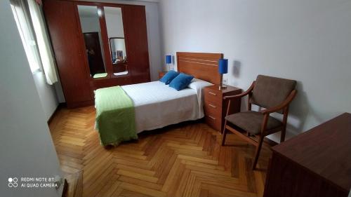 1 dormitorio pequeño con 1 cama y 1 silla en Apartment - 2 Bedrooms - 0137, en Cangas de Morrazo