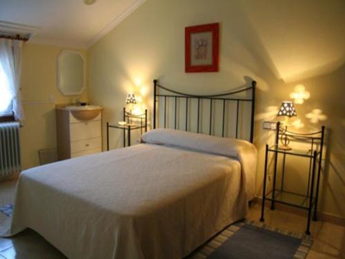 1 dormitorio con 1 cama blanca grande y 2 lámparas en House - 6 Bedrooms with Pool - 0126, en A Estrada