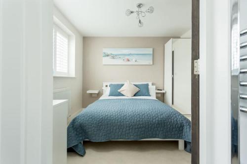 a bedroom with a bed with a blue comforter at Stunning 2 bed apartment, fabulous sea view & 2 minutes to beach with parking in Southbourne
